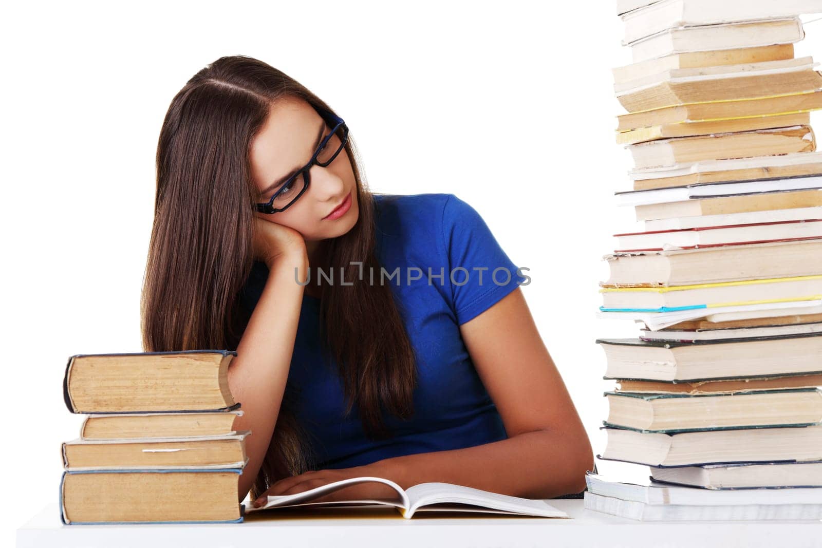Teen girl learning at the desk, isolated on white