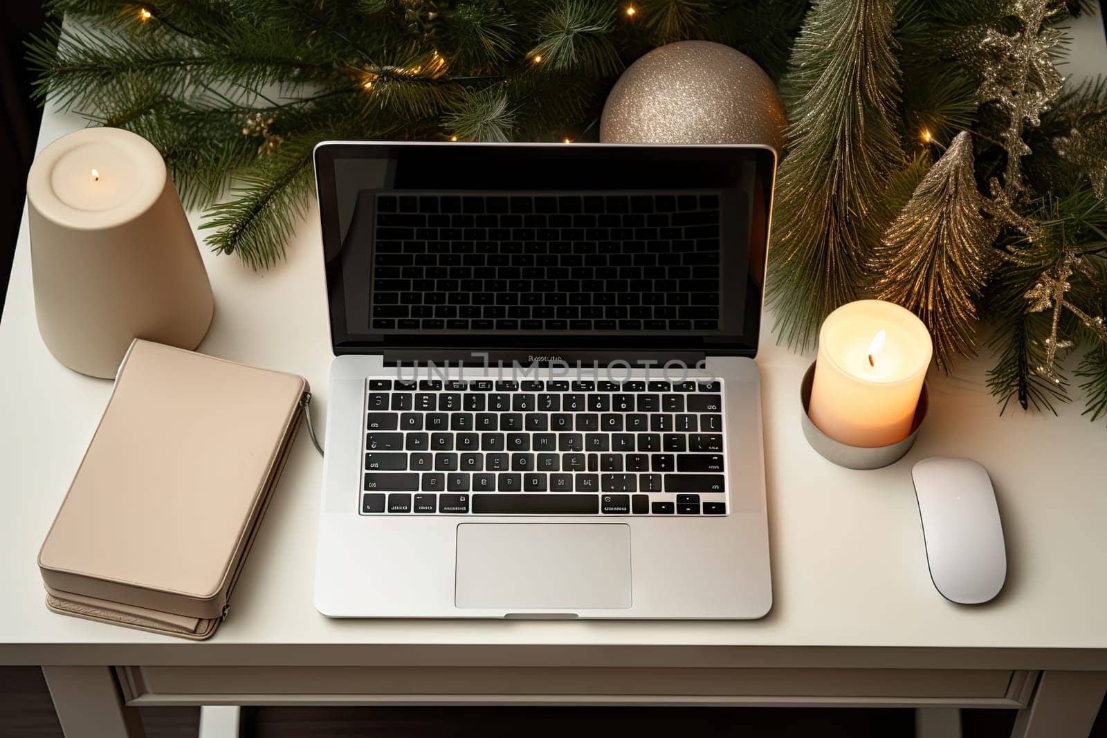 an open laptop computer sitting on a desk next to a christmas tree with candles, books and a lit candle