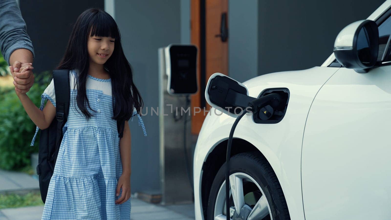 Progressive concept of father and daughter with EV car and charging station. by biancoblue