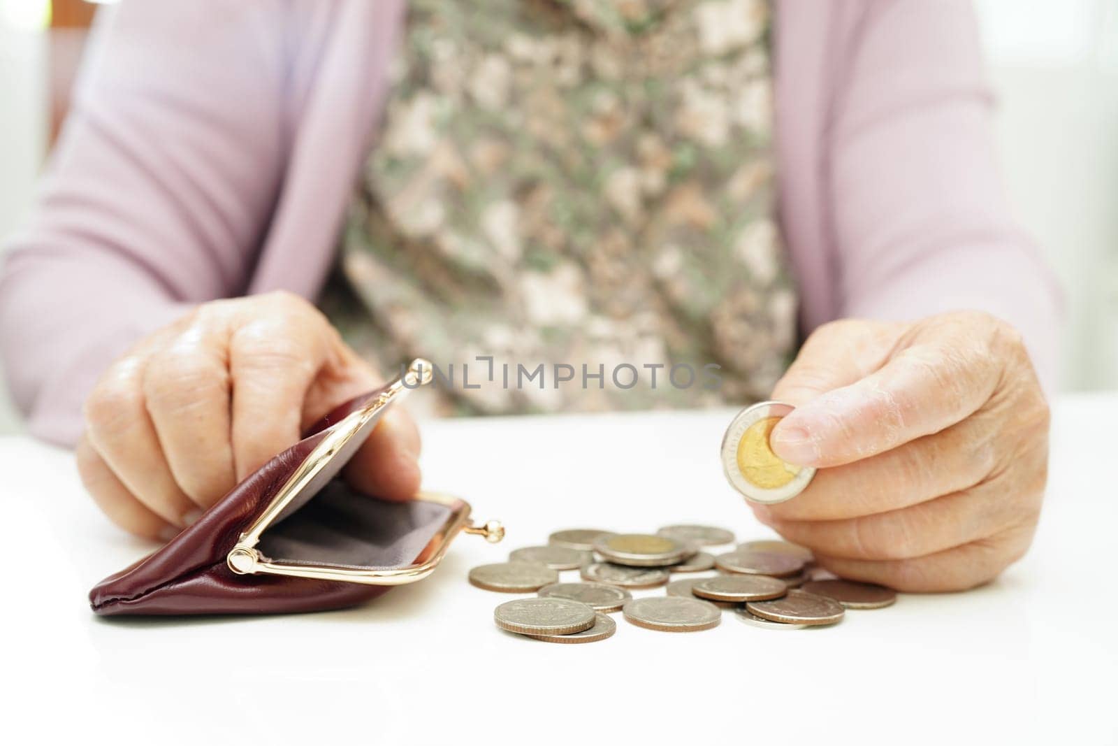 Retired elderly woman counting coins money and worry about monthly expenses and treatment fee payment. by sweettomato