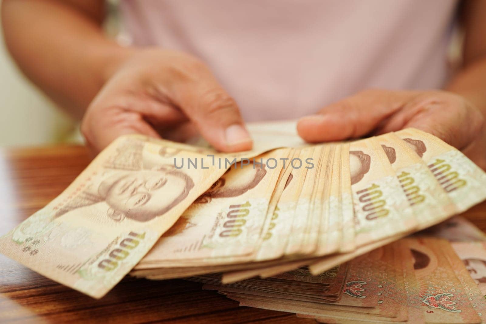 Asian woman counting Thai baht banknote money and holding in hand, investment economy, accounting business and banking. by sweettomato