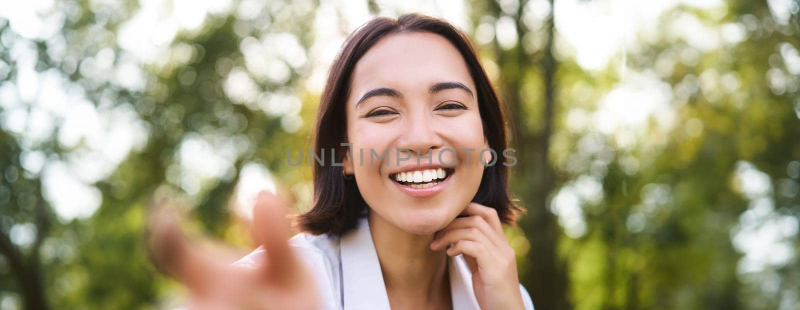 Genuine people. Portrait of asian woman laughing and smiling, walking in park, feeling joy and positivity.