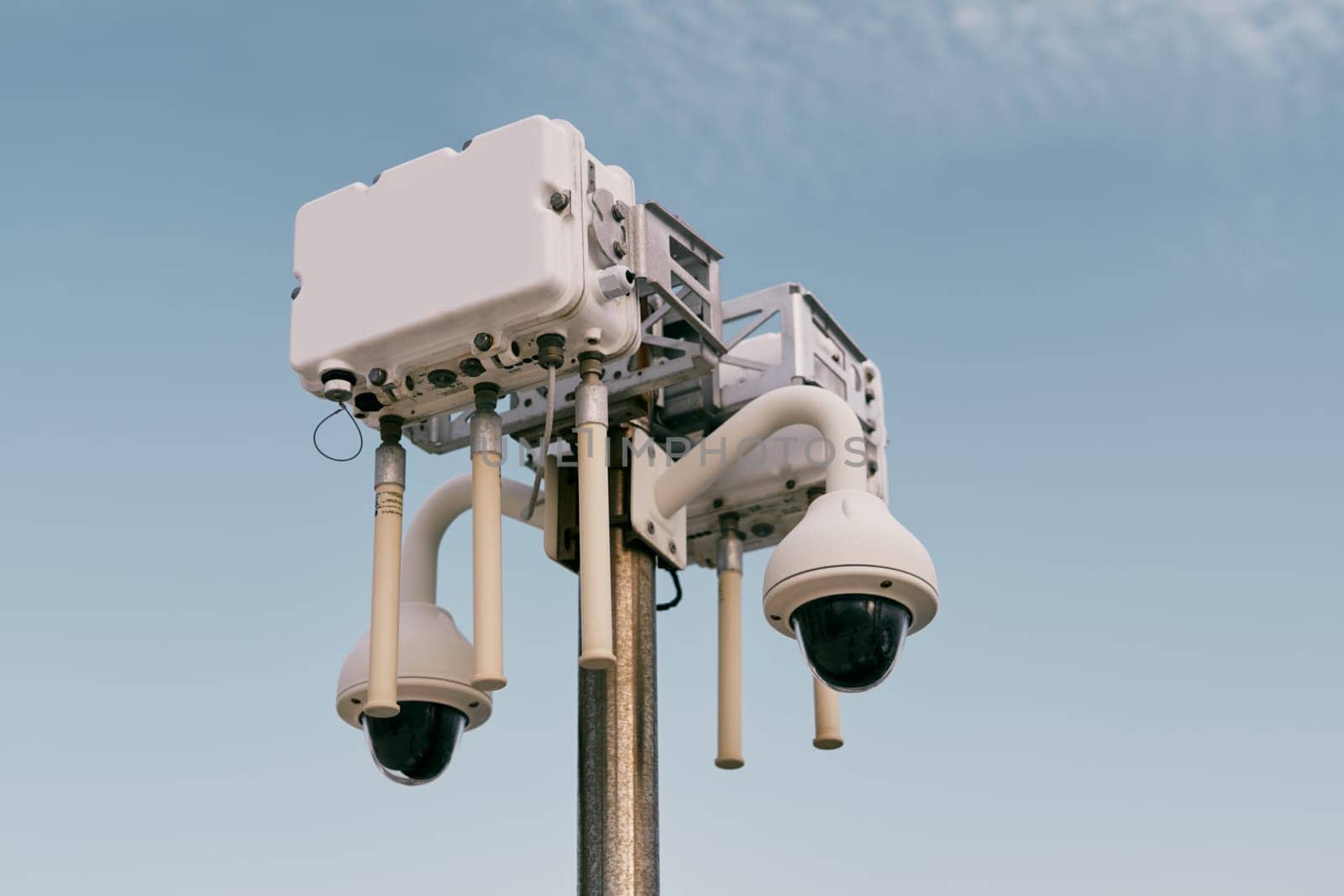 Street wi-fi router on a pole with video cameras against the sky by Nadtochiy