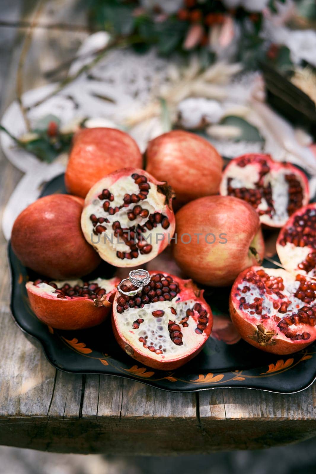 Wedding rings lie on half a pomegranate on the table. High quality photo