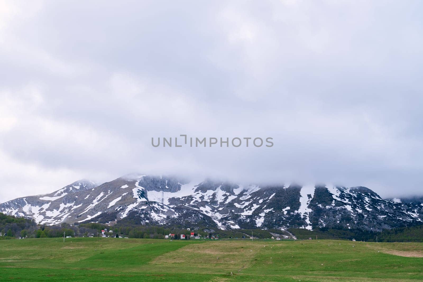 Fog descends over the snowy peaks of the highlands by Nadtochiy