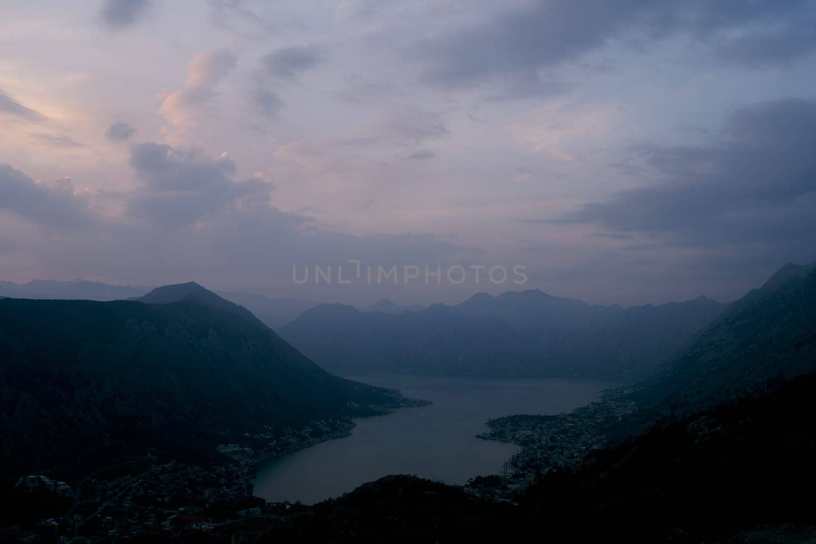 Panorama of the Bay of Kotor surrounded by a mountain range at dusk at sunset. Drone. High quality photo