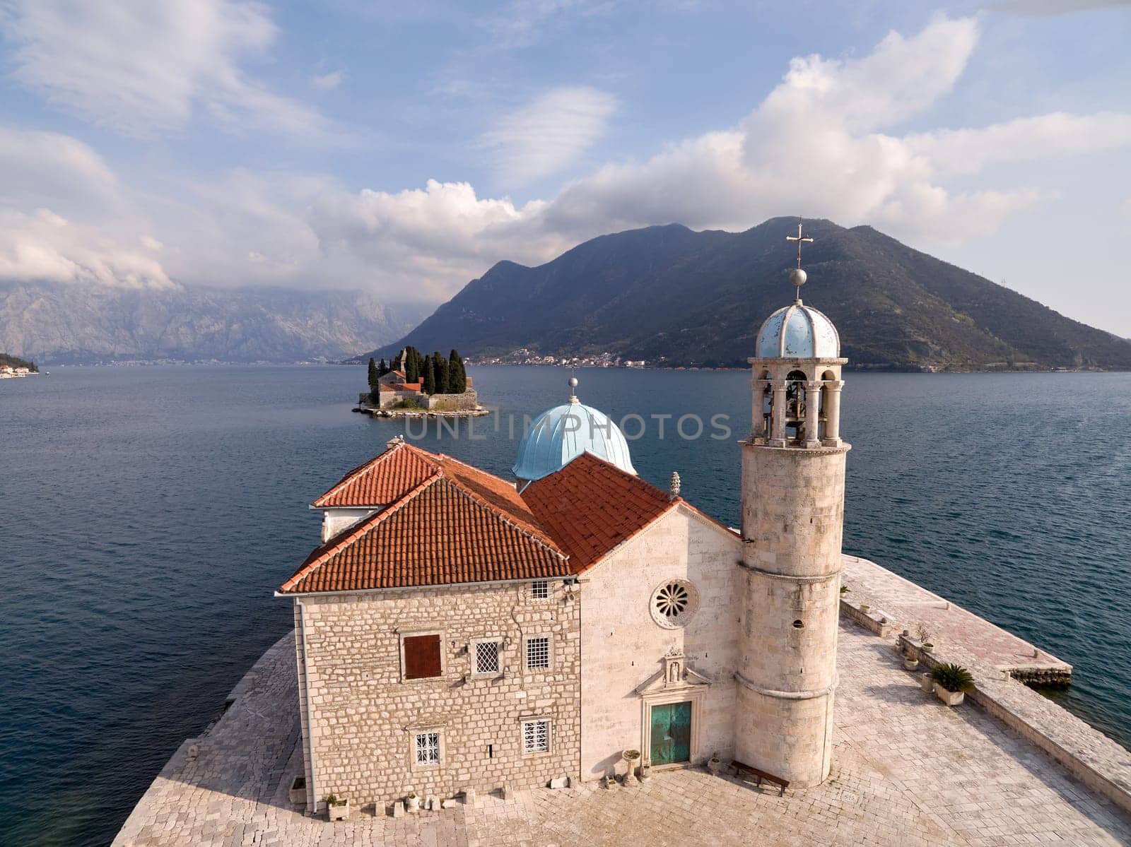 Ancient stone church of Our Lady on the rocks on the island of Gospa od Skrpjela Montenegro. Drone by Nadtochiy