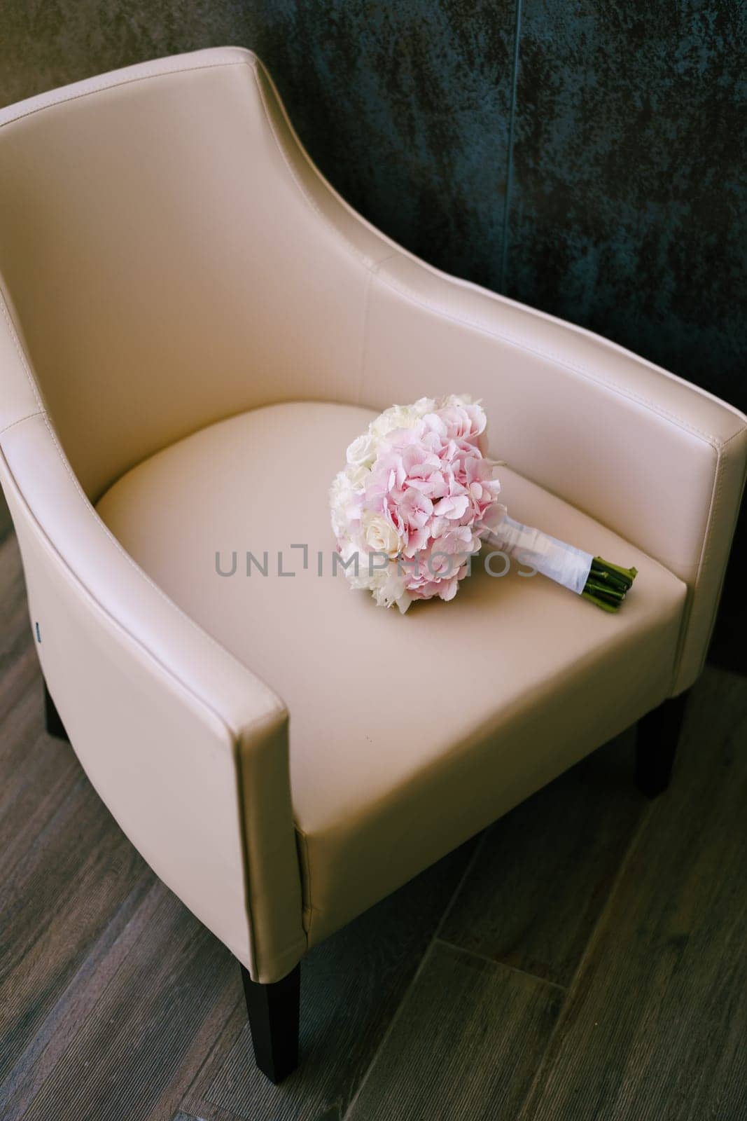 Wedding bouquet lies on a beige armchair in the room. High quality photo