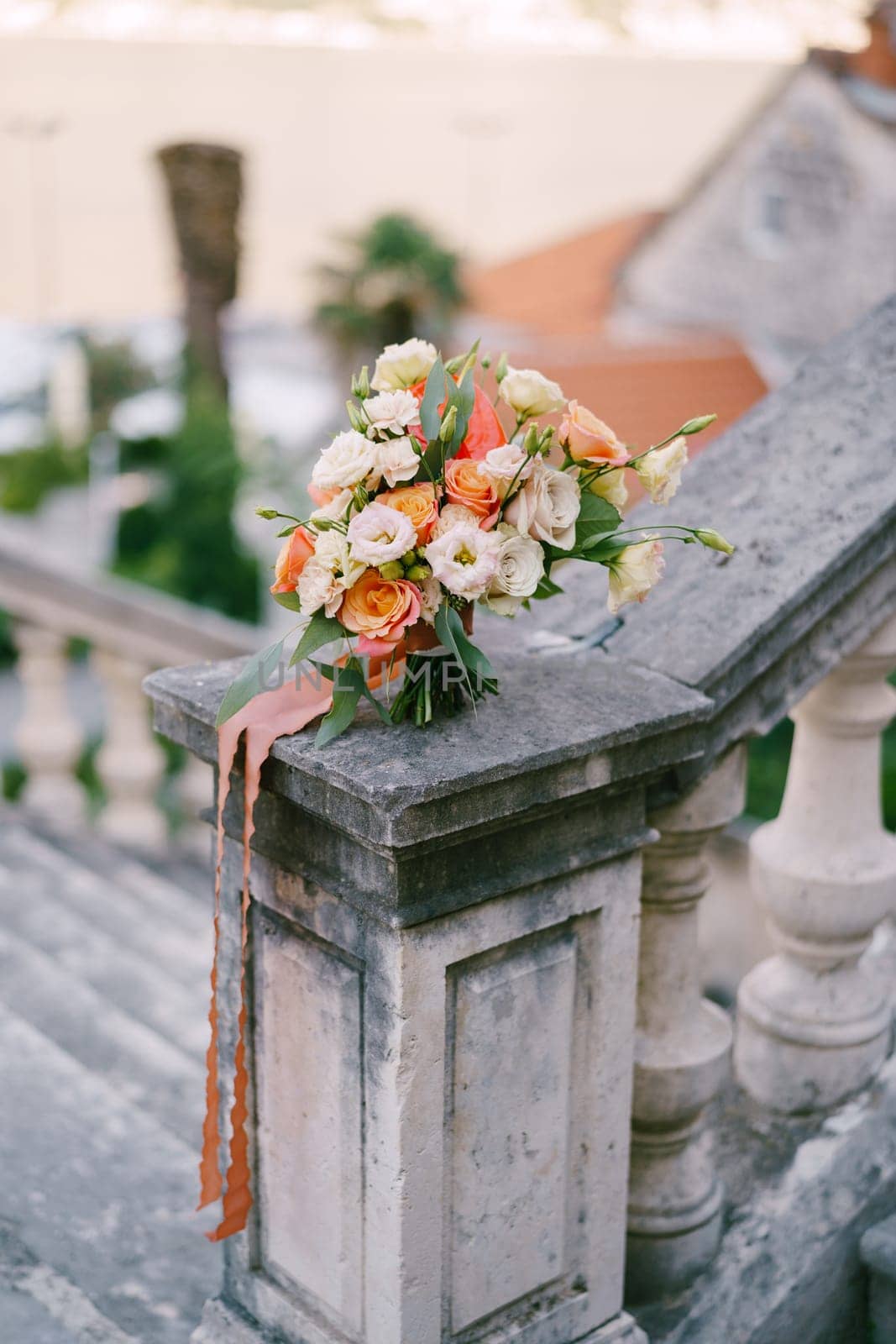 Bridal bouquet stands on the stone handrail of an ancient balustrade in the garden. High quality photo
