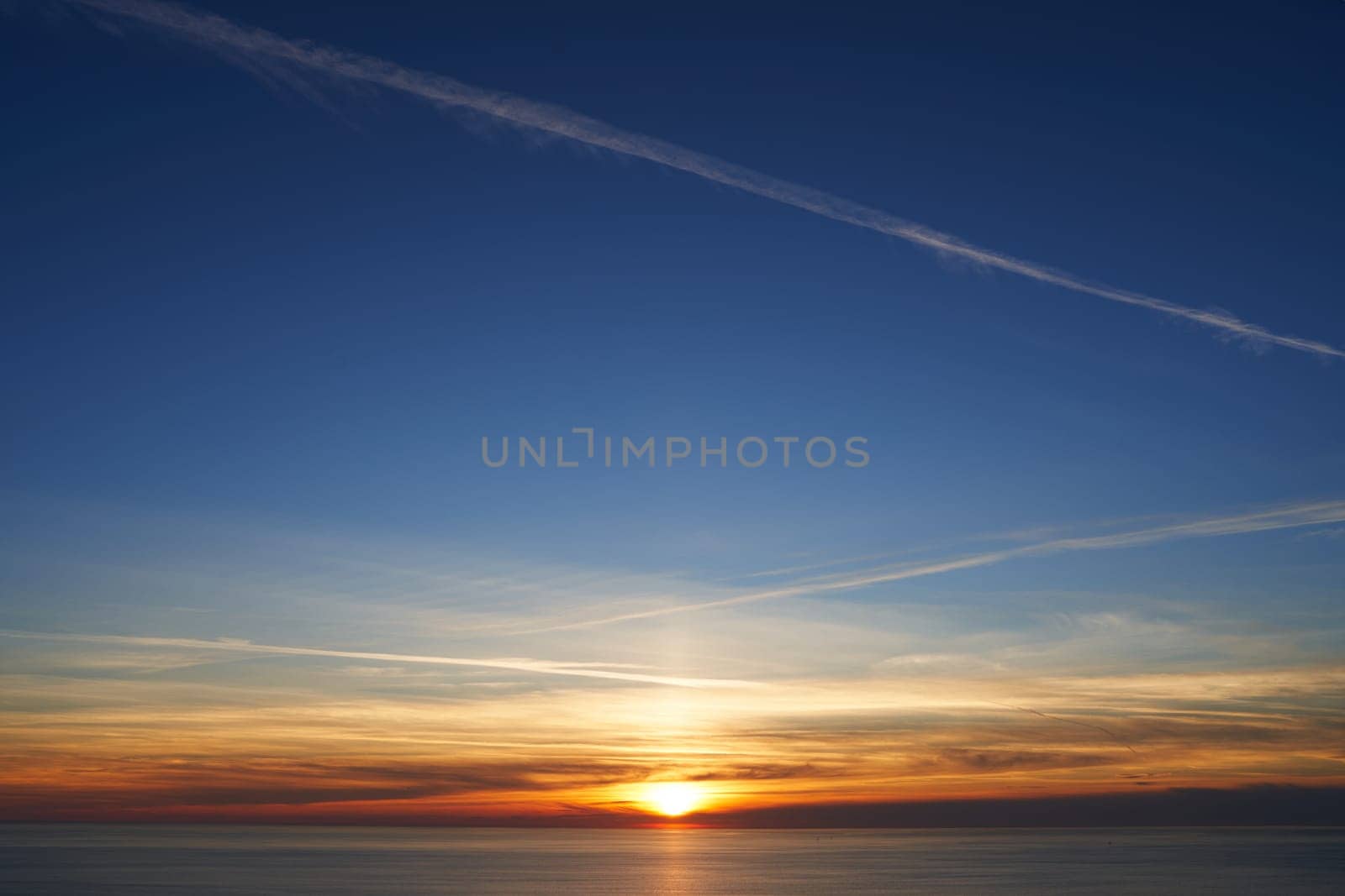 Orange sunset on the blue sky over the sea. High quality photo