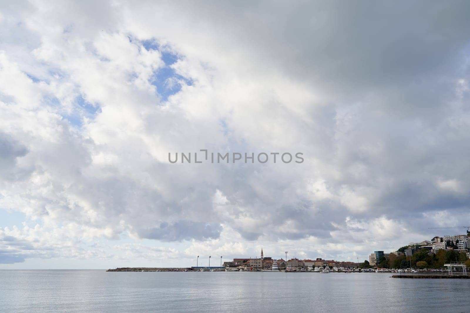Cloudy sky over an ancient town on the coast. High quality photo