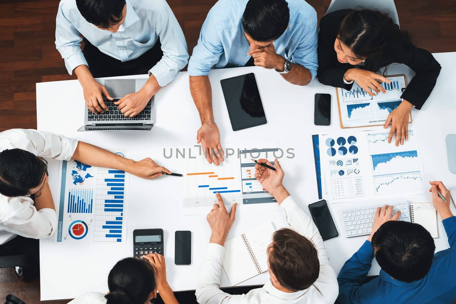 Top view project manager communicate and collaborate with team using project management software, tracking progress of project task and making schedule plan at meeting table. Prudent