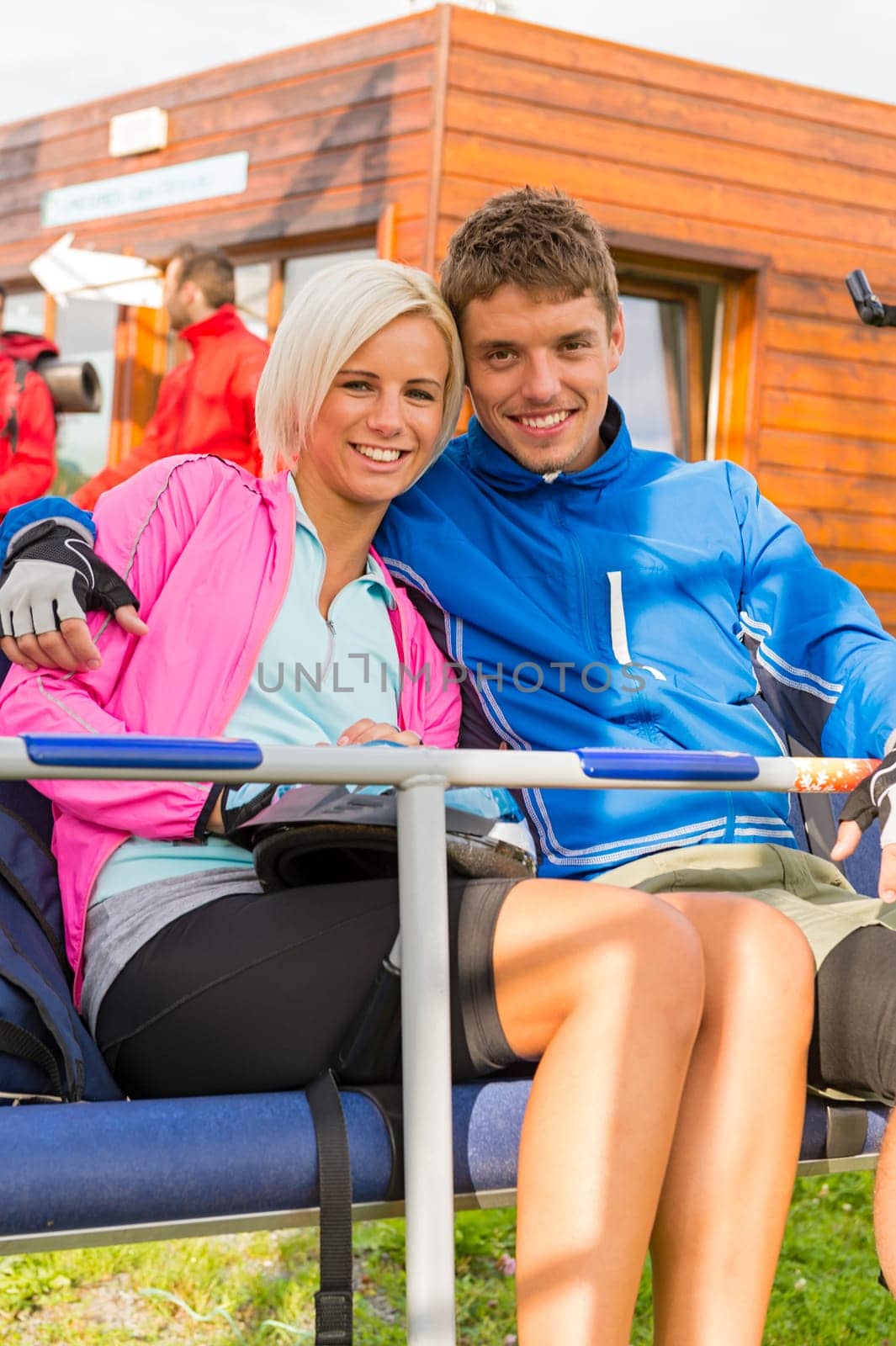 Smiling young couple sitting together on char lift