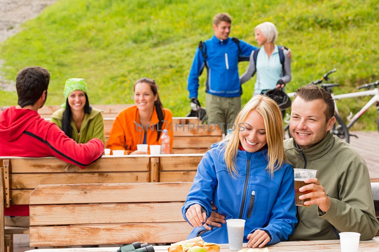 Cheerful people enjoying springtime weekend in rest area drinking beer