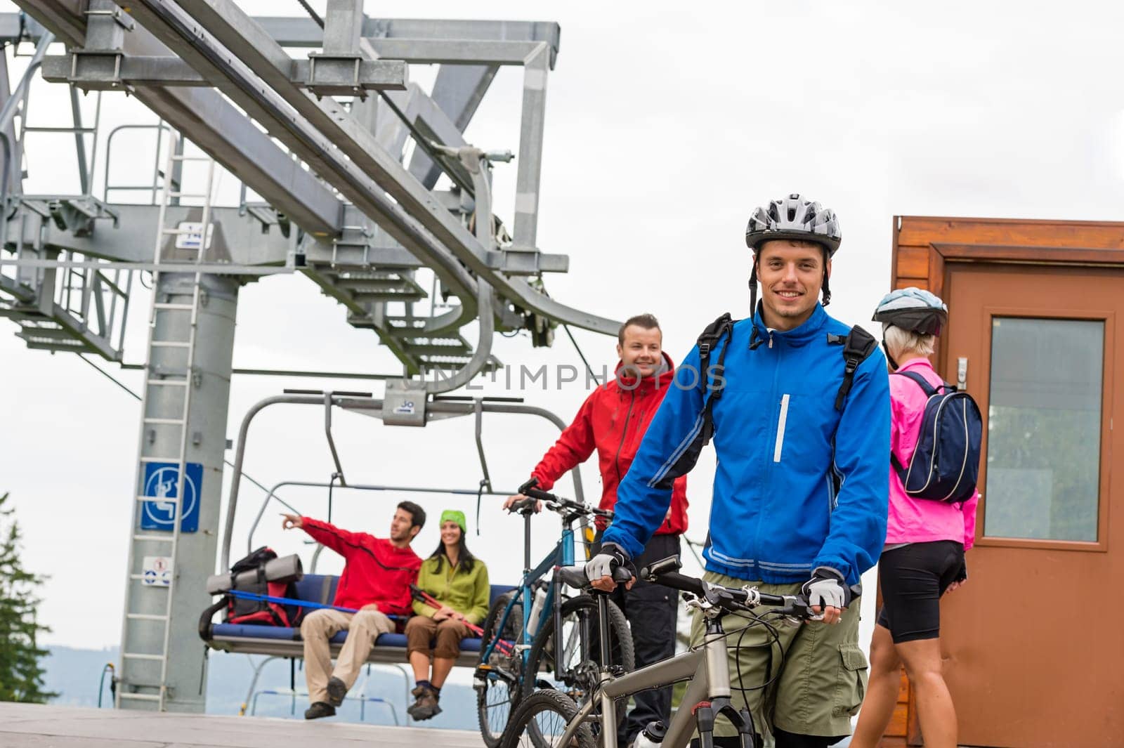 Sporty couple getting on bicycles after chair lift trip