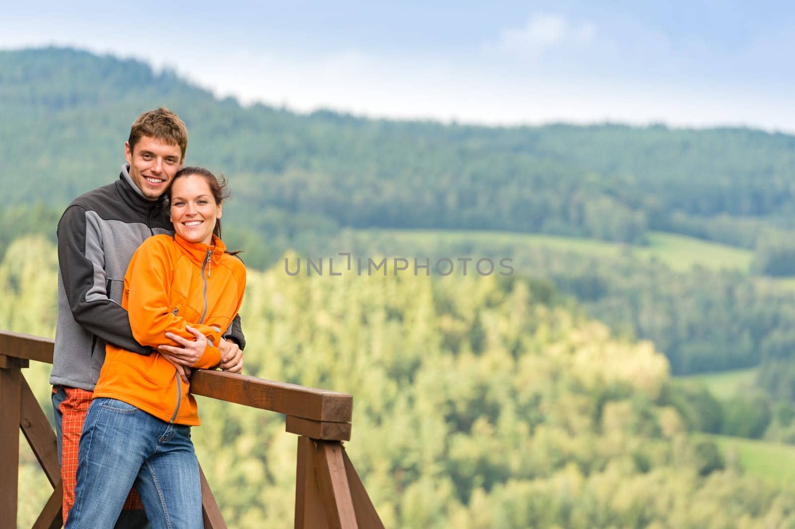 Cuddling couple on a summer weekend at the top of the mountain