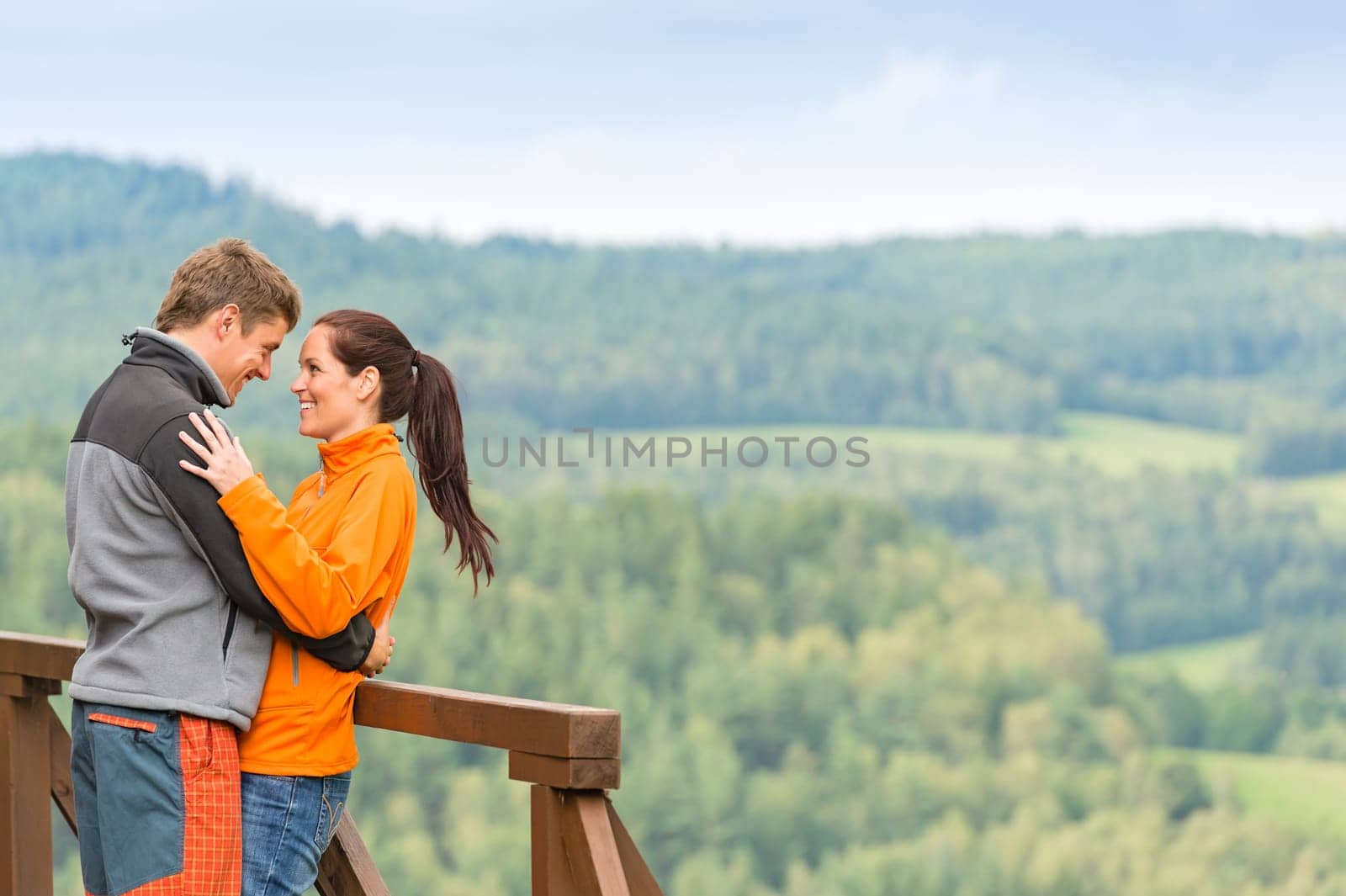 Romantic couple looking at each other on landscape background