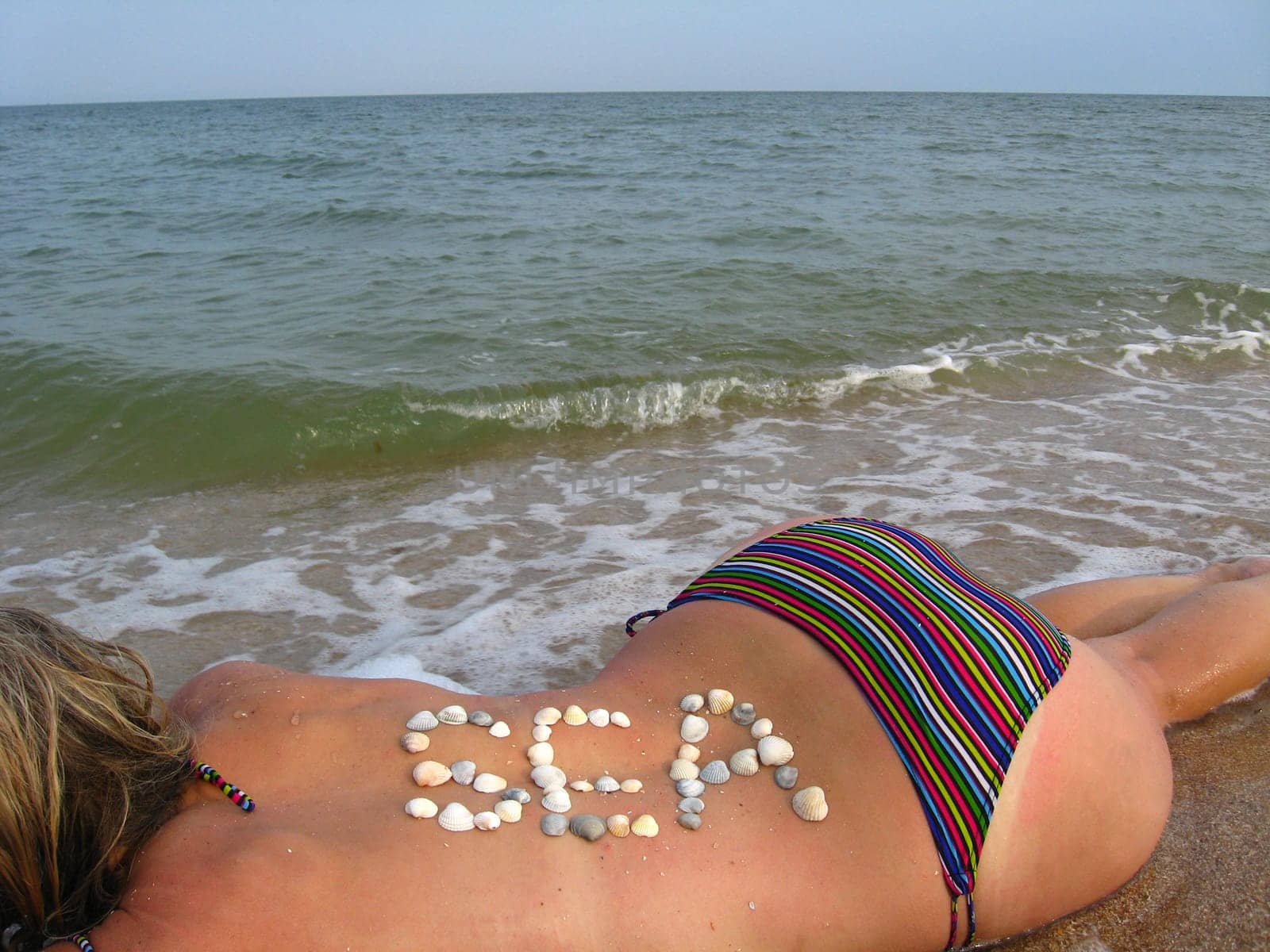 image of inscription from cockleshells on the body of the girl