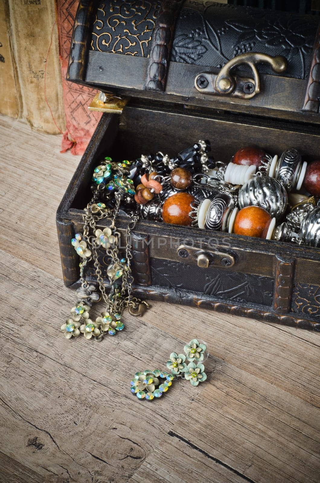 casket with jewelry and old book on a wooden surface