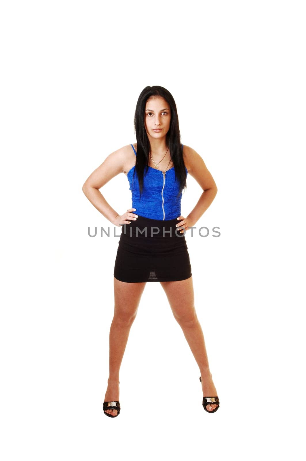 A pretty teen girl in a blue corset and black skirt standing from the front for white background.