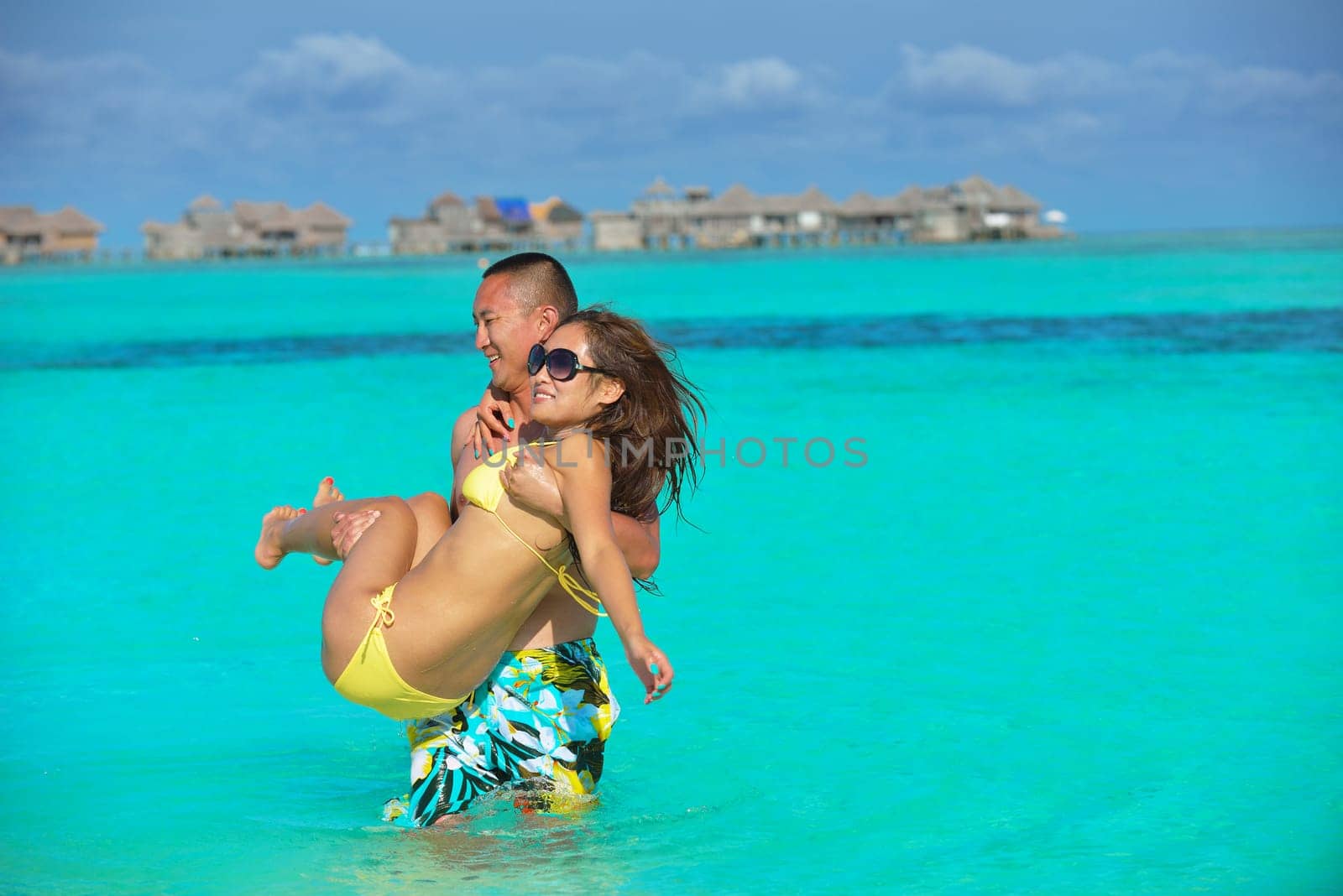 happy young asian couple have fun and romantic time at  summer on beautiful white sand beach