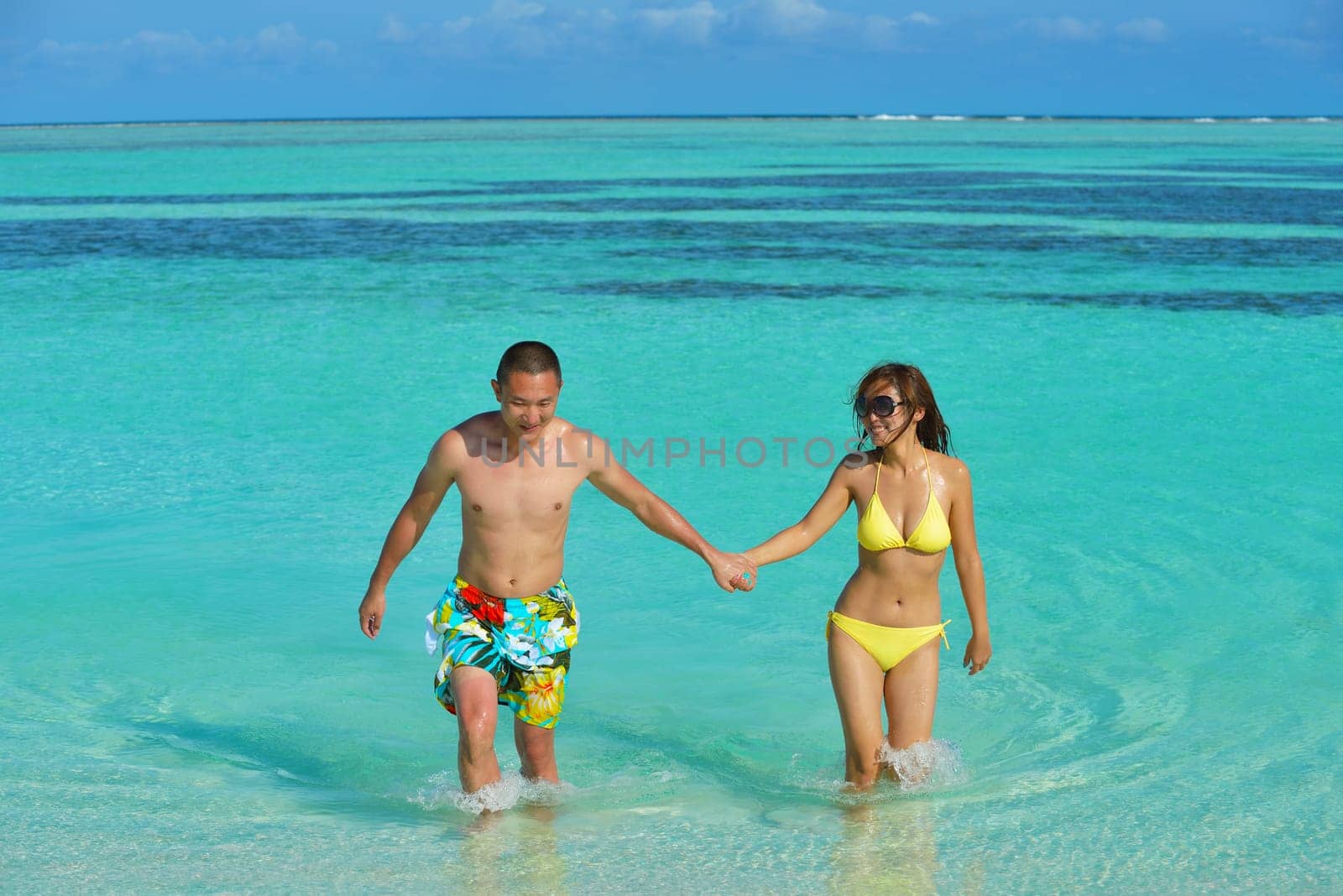 happy young asian couple have fun and romantic time at  summer on beautiful white sand beach