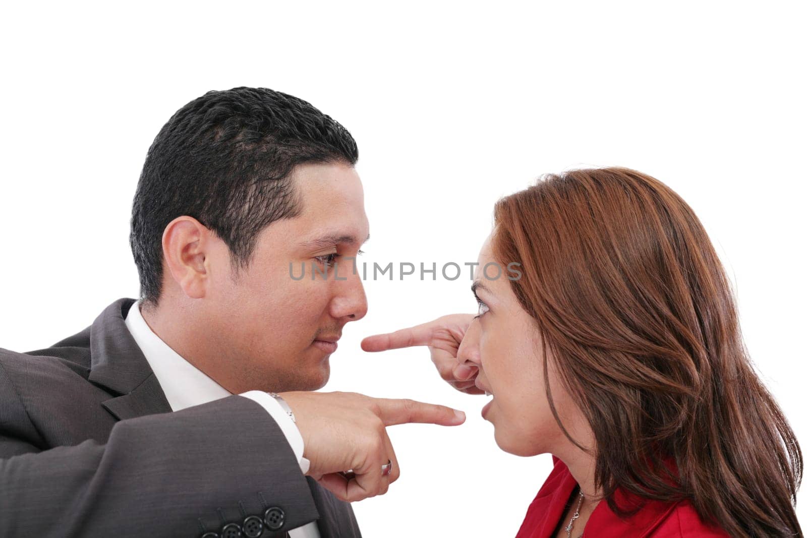 Young couple pointing at each other against a white background