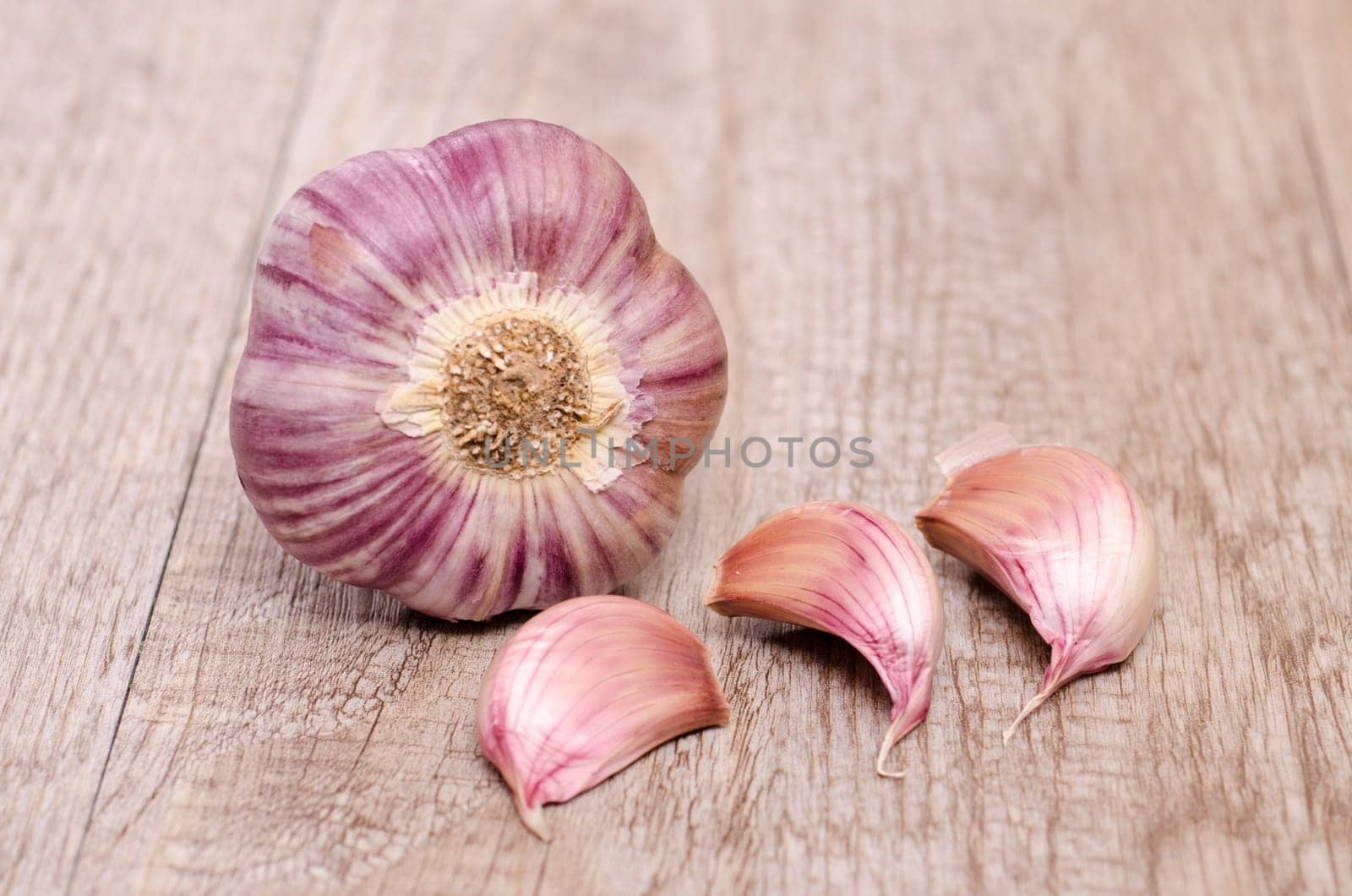 Garlic with garlic cloves on weathered wood