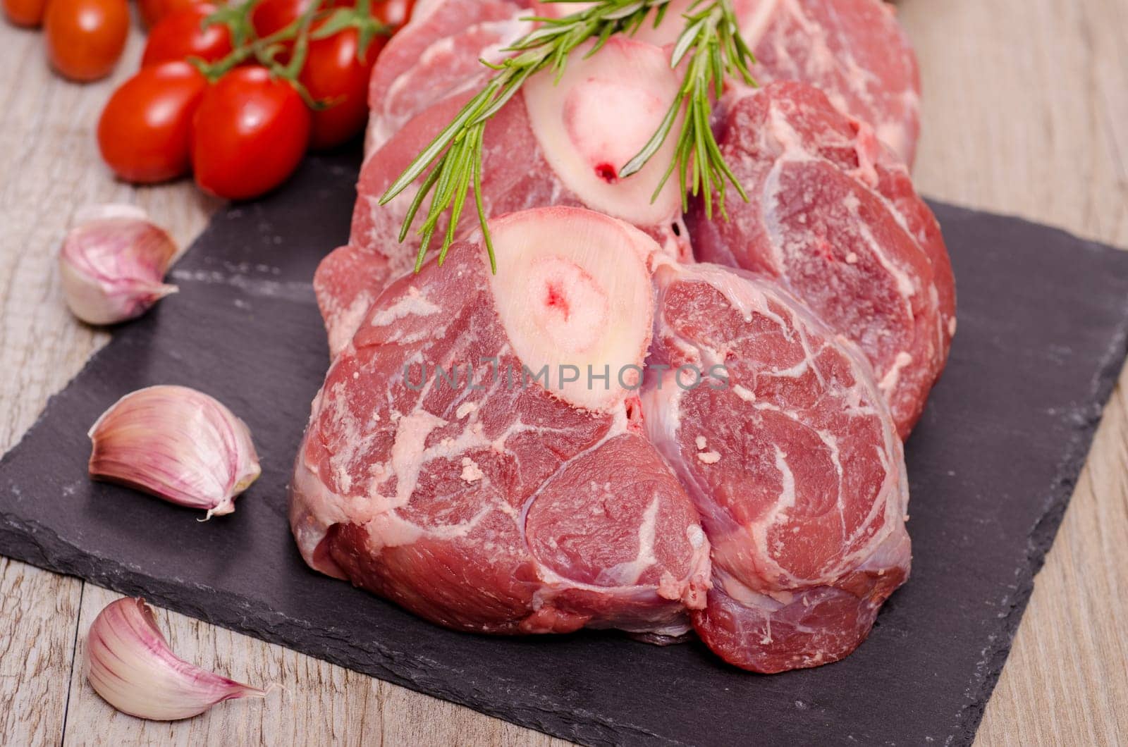 Veal leg slices and garlic cloves