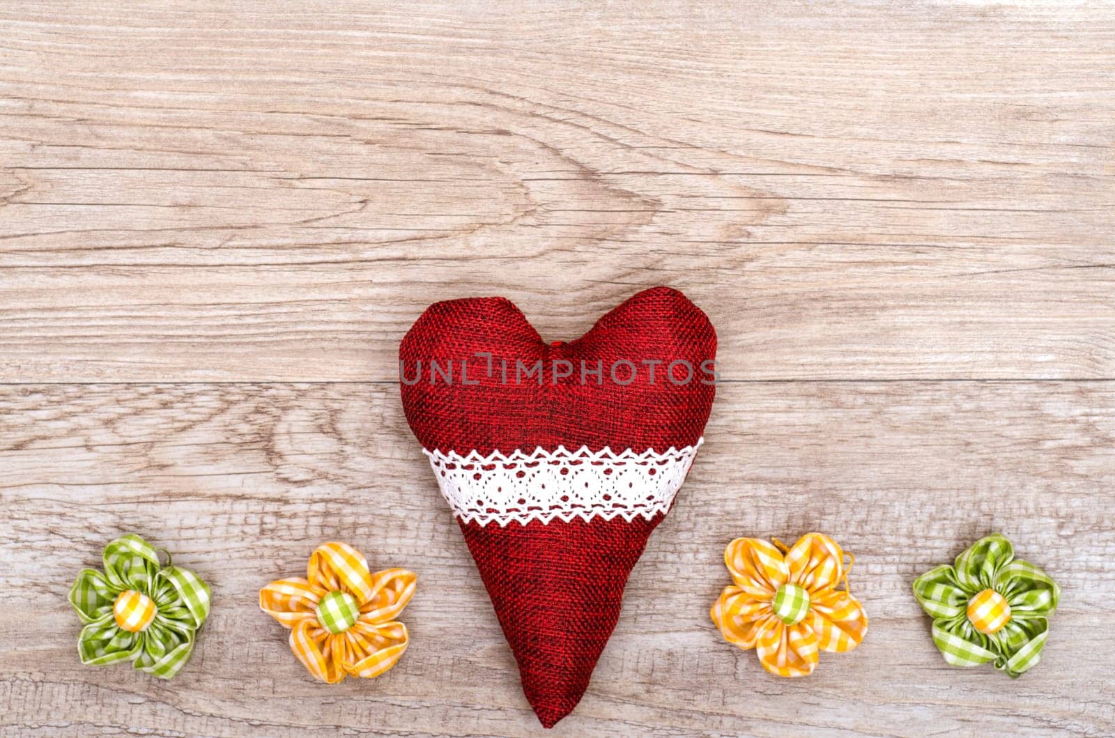 Red fabric heart and fabric flowers on weathered old wood