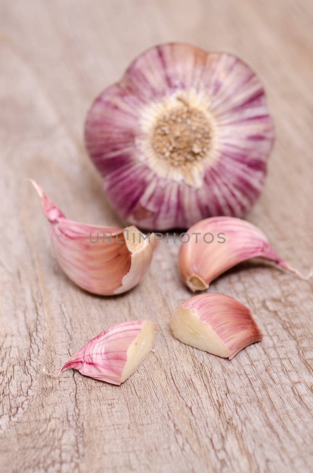 Garlic with garlic cloves on old wooden board