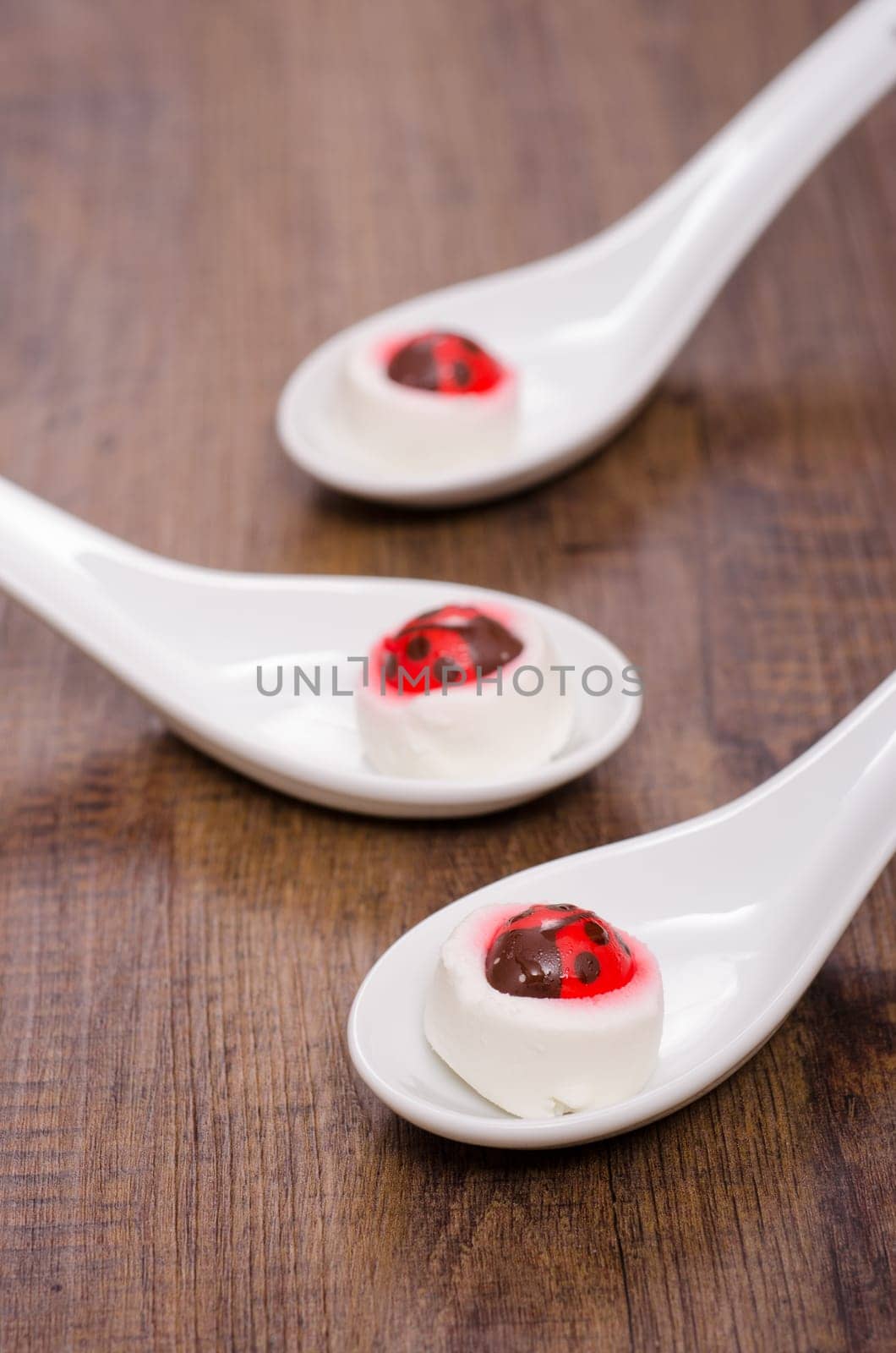 Goat cheese with frosting ladybug on porcelain spoon