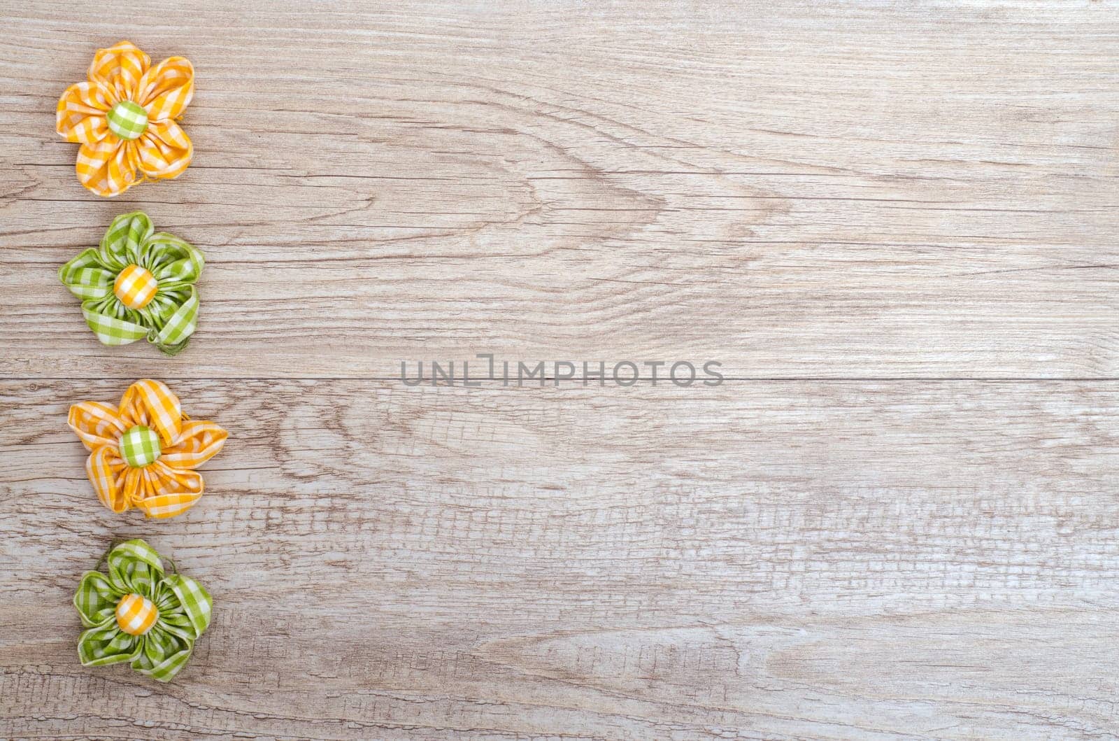 Weathered wooden board with fabric flowers and free copy space as an advertising sign