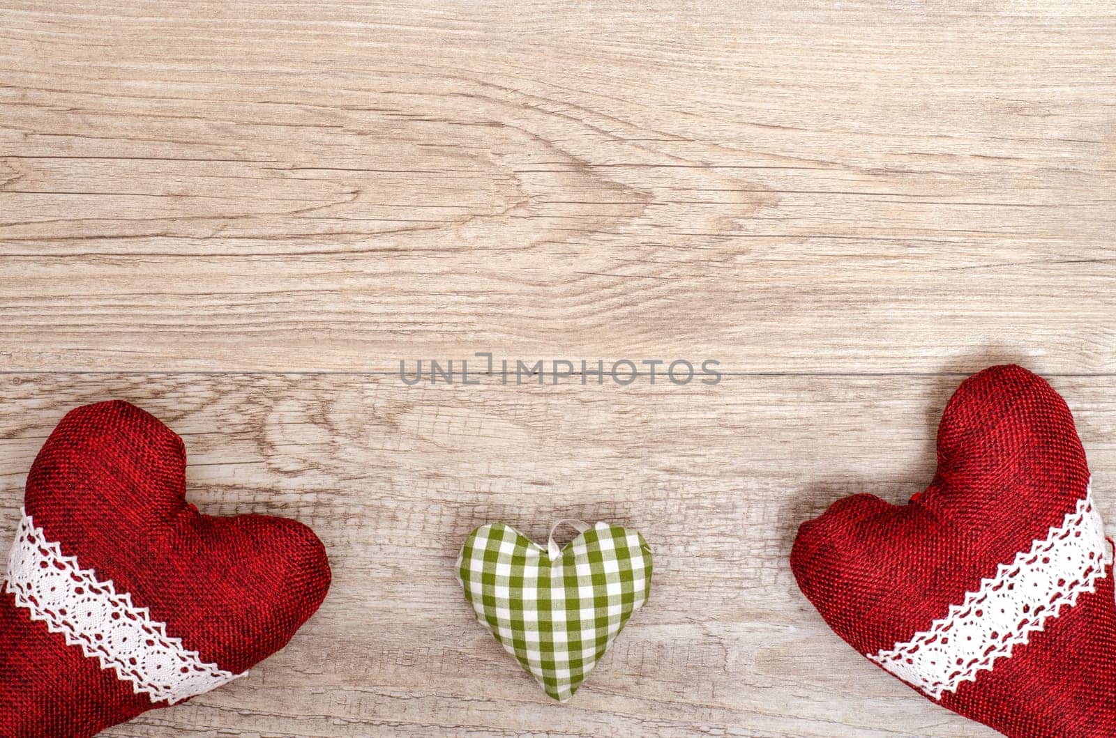 Text space for congratulations on a wooden board with three hearts made of fabric