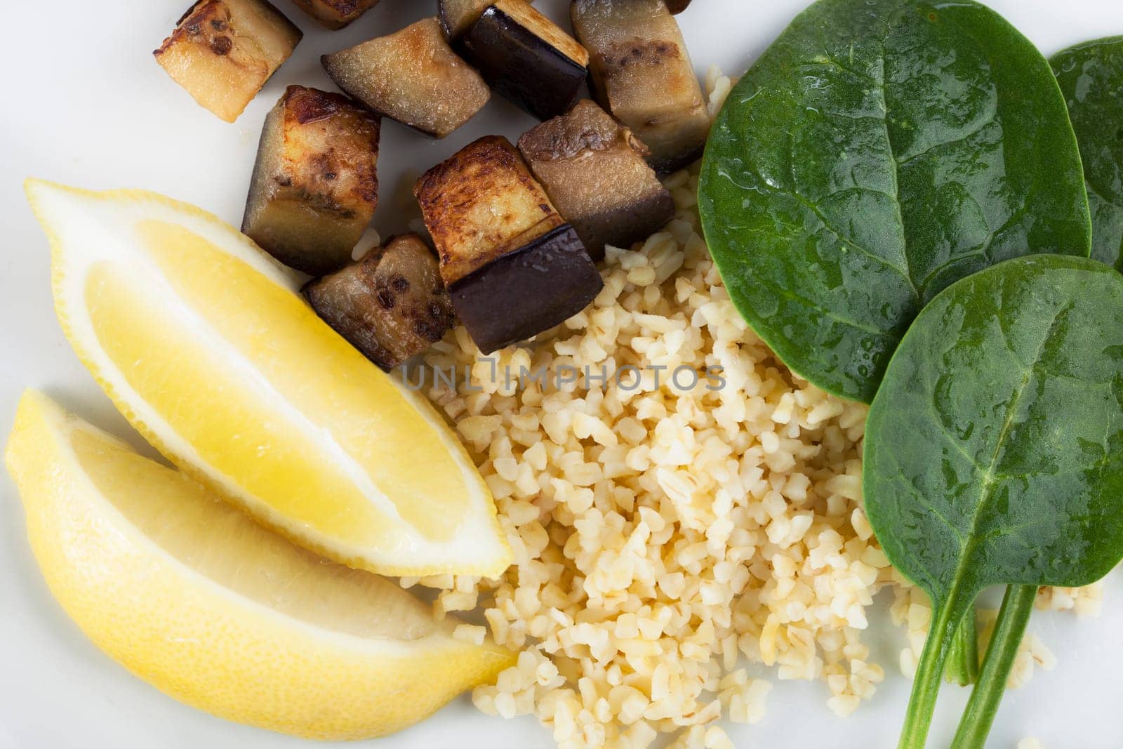 Fresh vegetable ingredients with spinach, eggplant/aubergine, lemon and bulgar