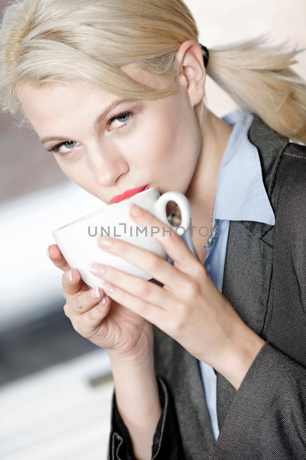 professional business woman drinking a mug of coffee at work.
