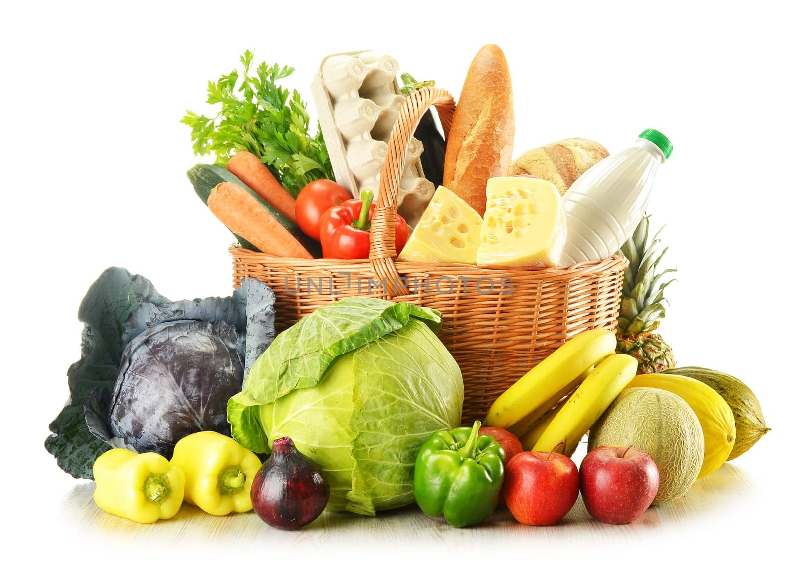 Wicker basket with variety of grocery products isolated on white