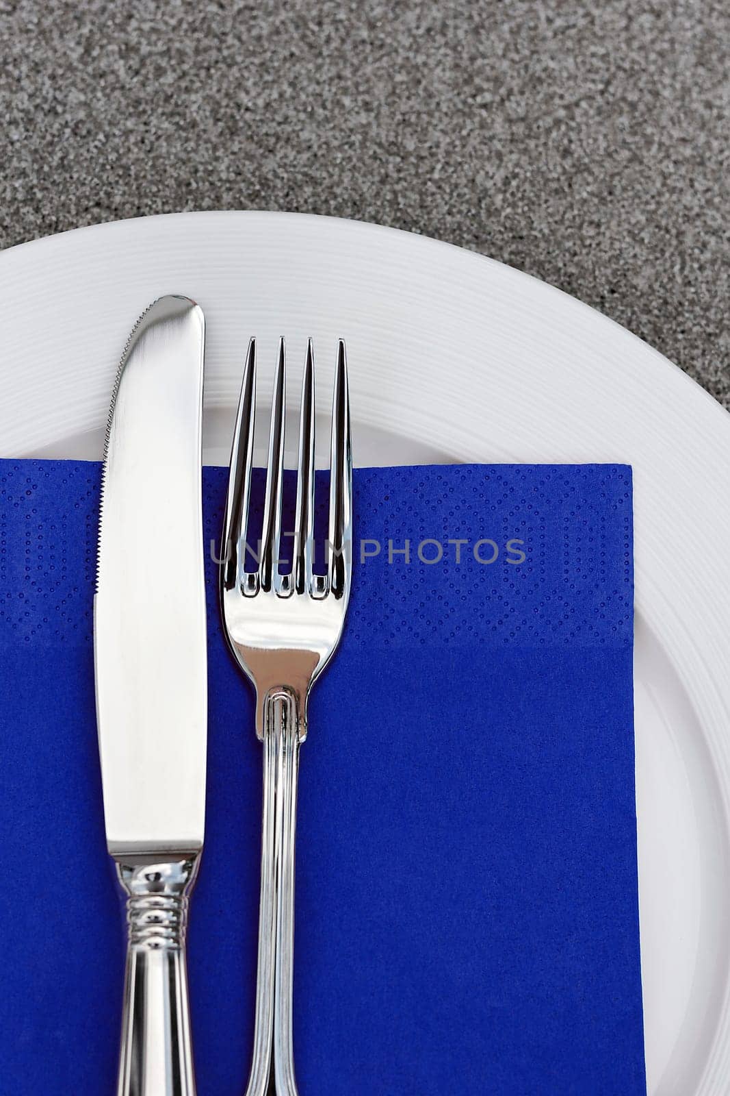 Plate with cutlery and blue napkin