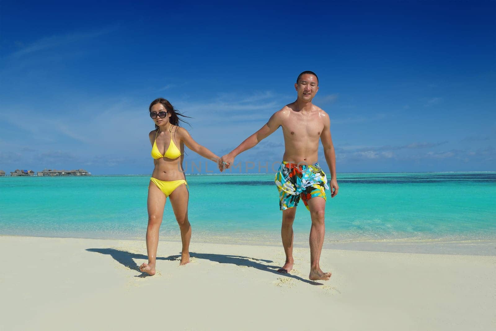 happy young asian couple have fun and romantic time at  summer on beautiful white sand beach