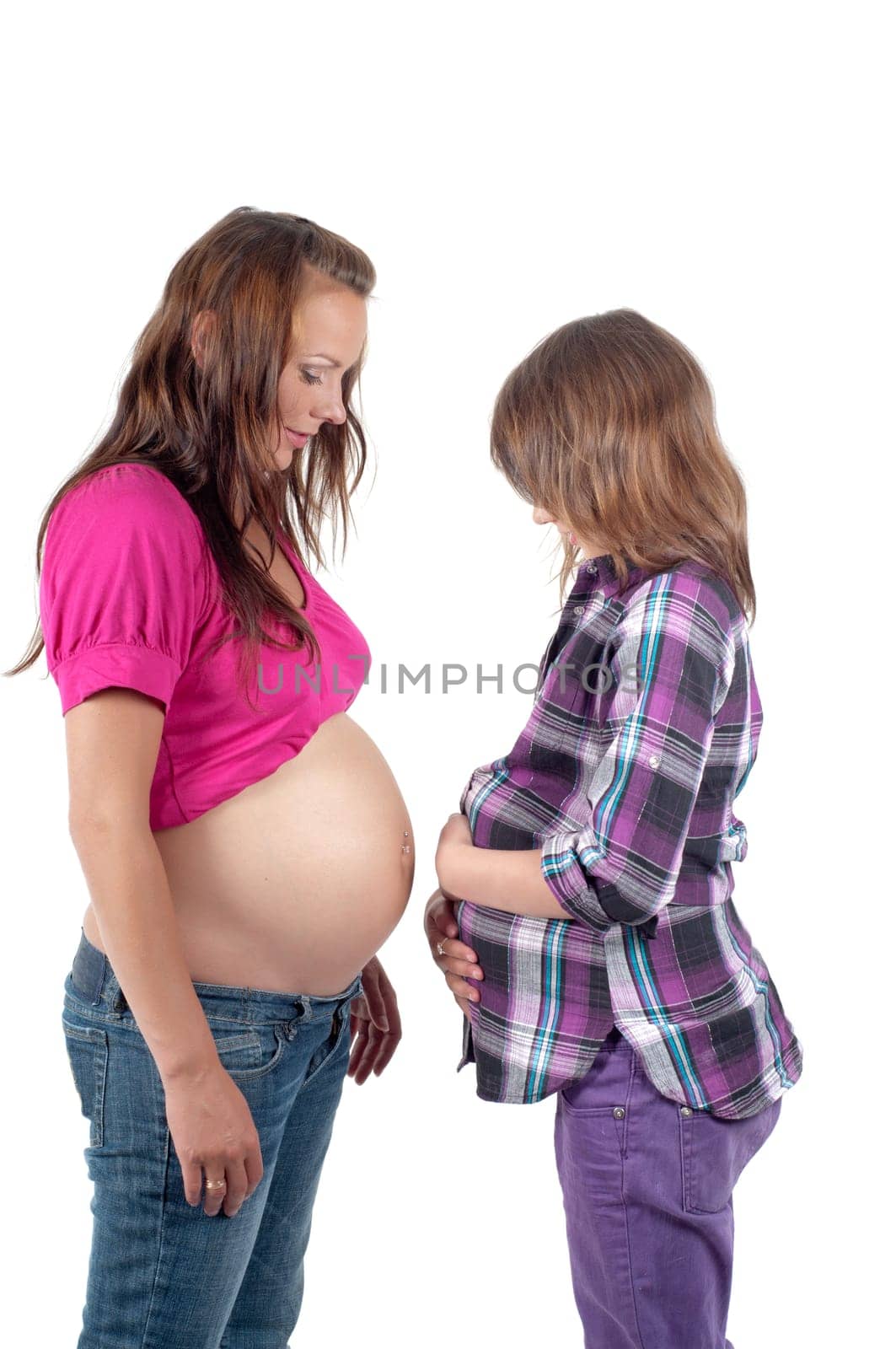 Beautiful pregnant woman with daughter in studio isolated on white