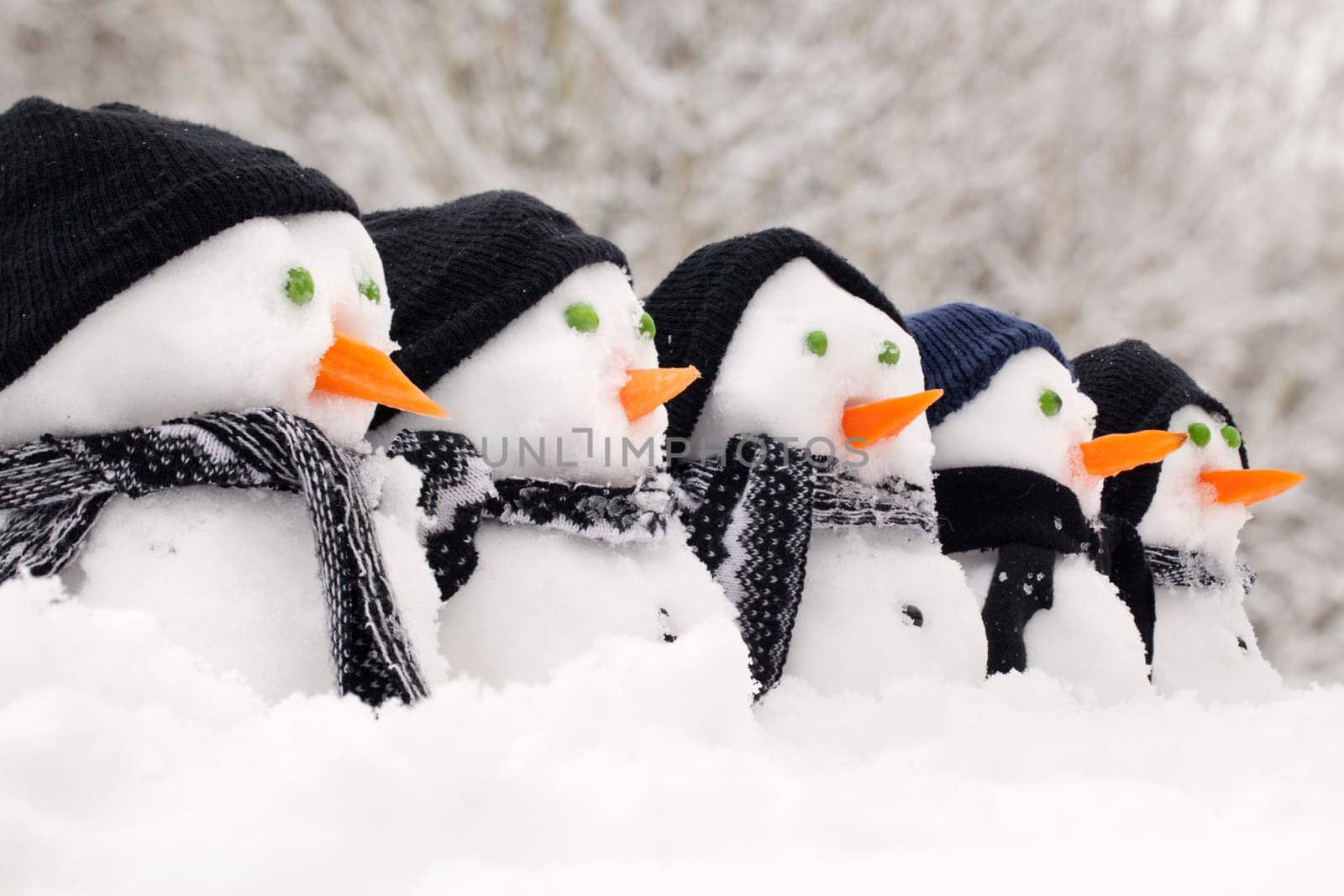 Snowmen close up in a row with hats and scarfs