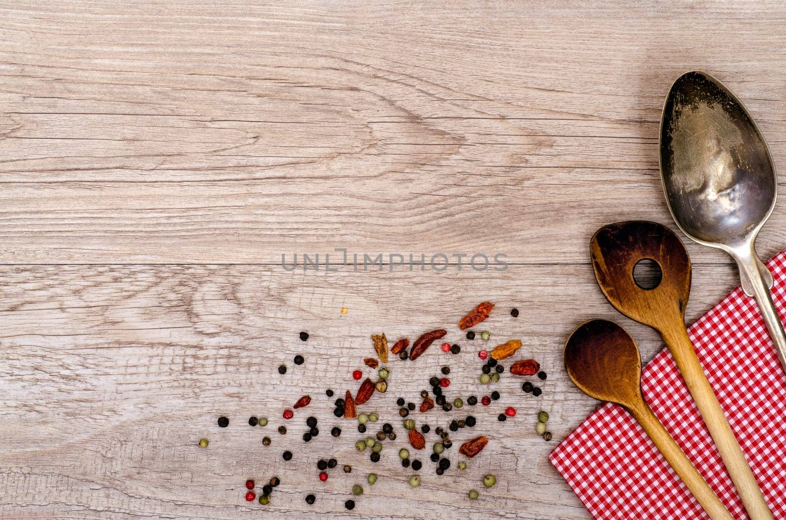 Old wooden wooden spoons and silver spoons with red and white checkered cloth