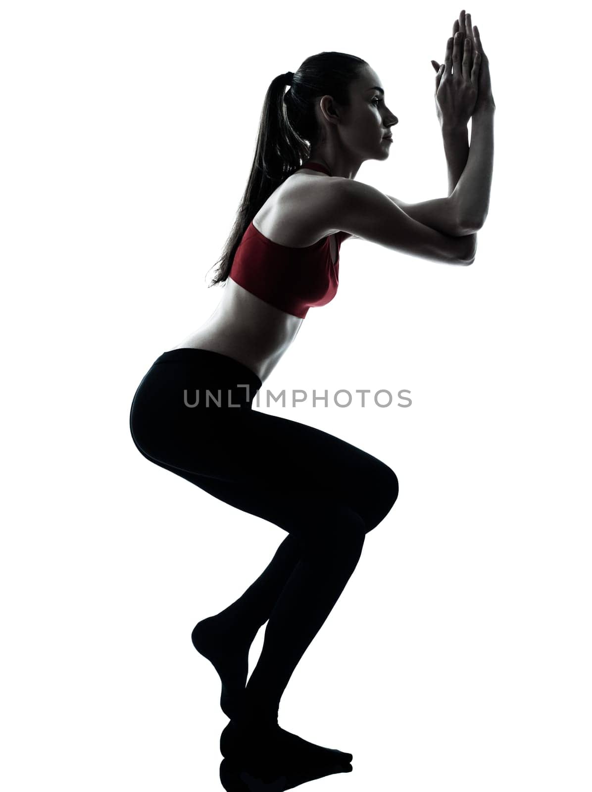 one caucasian woman exercising Garudasana eagle pose in silhouette studio isolated on white background