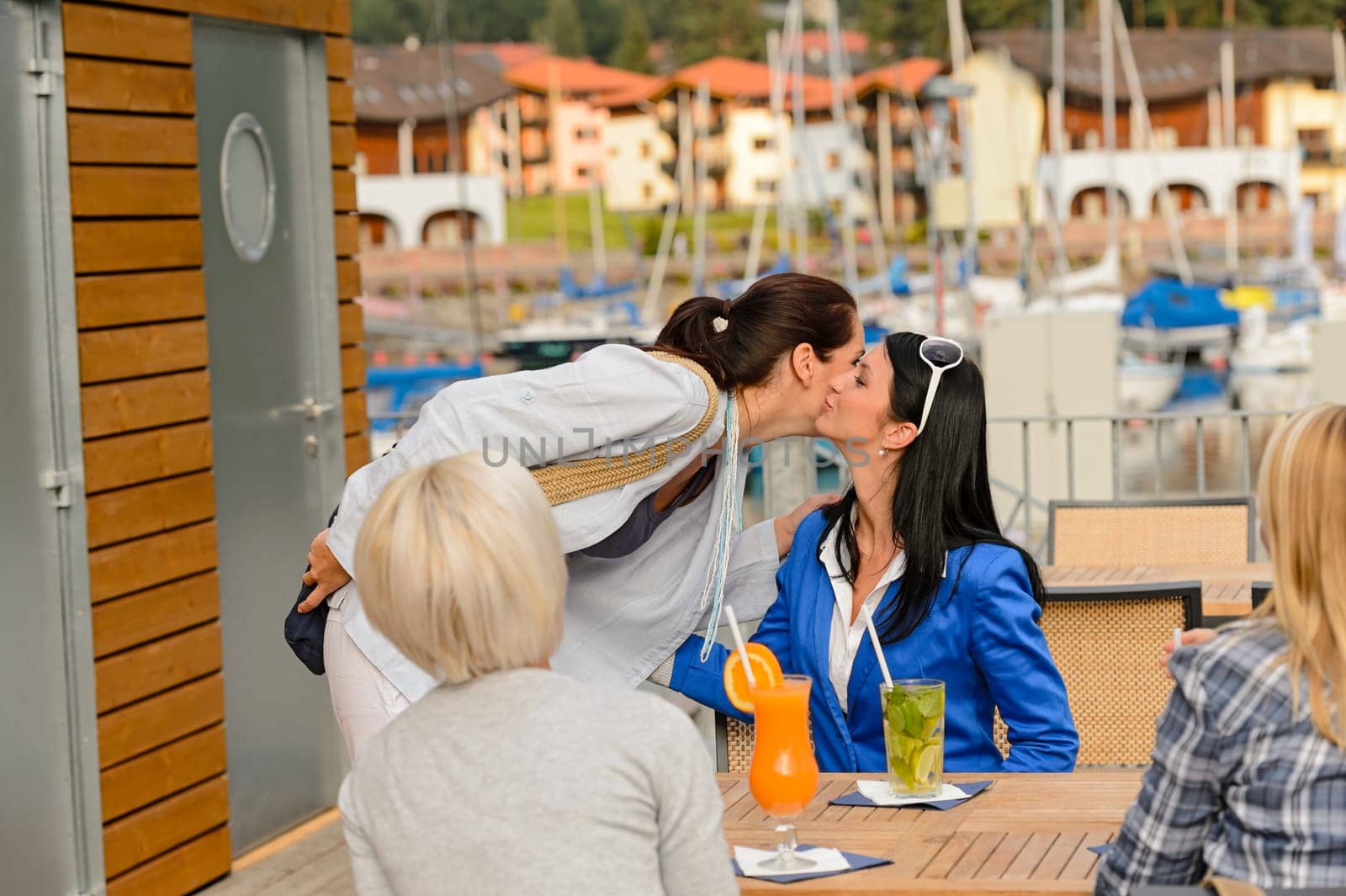 Woman saying goodbye to her friends at outdoor restaurant terrace