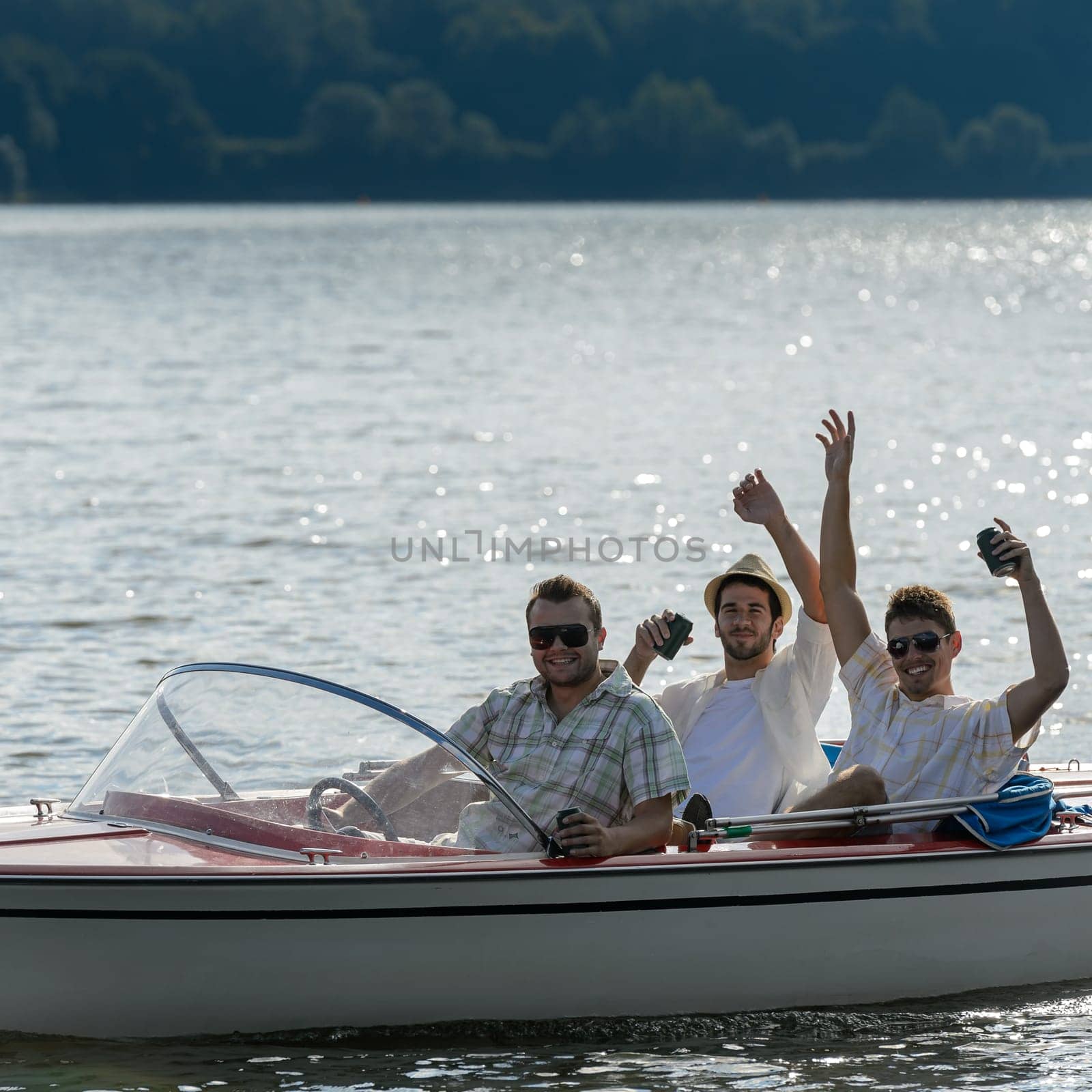 Cheerful young men party drinking beer on speed boat