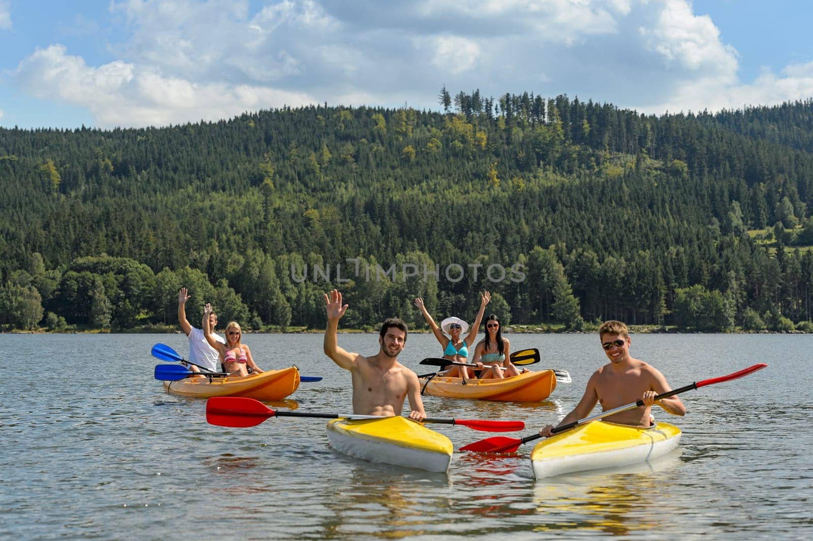 Young kayaking friends having fun in scenic view summer holiday