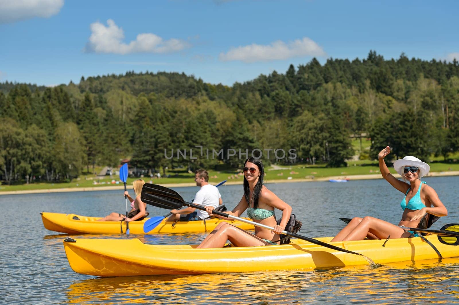 Friends enjoying summertime kayaking on river holiday freetime