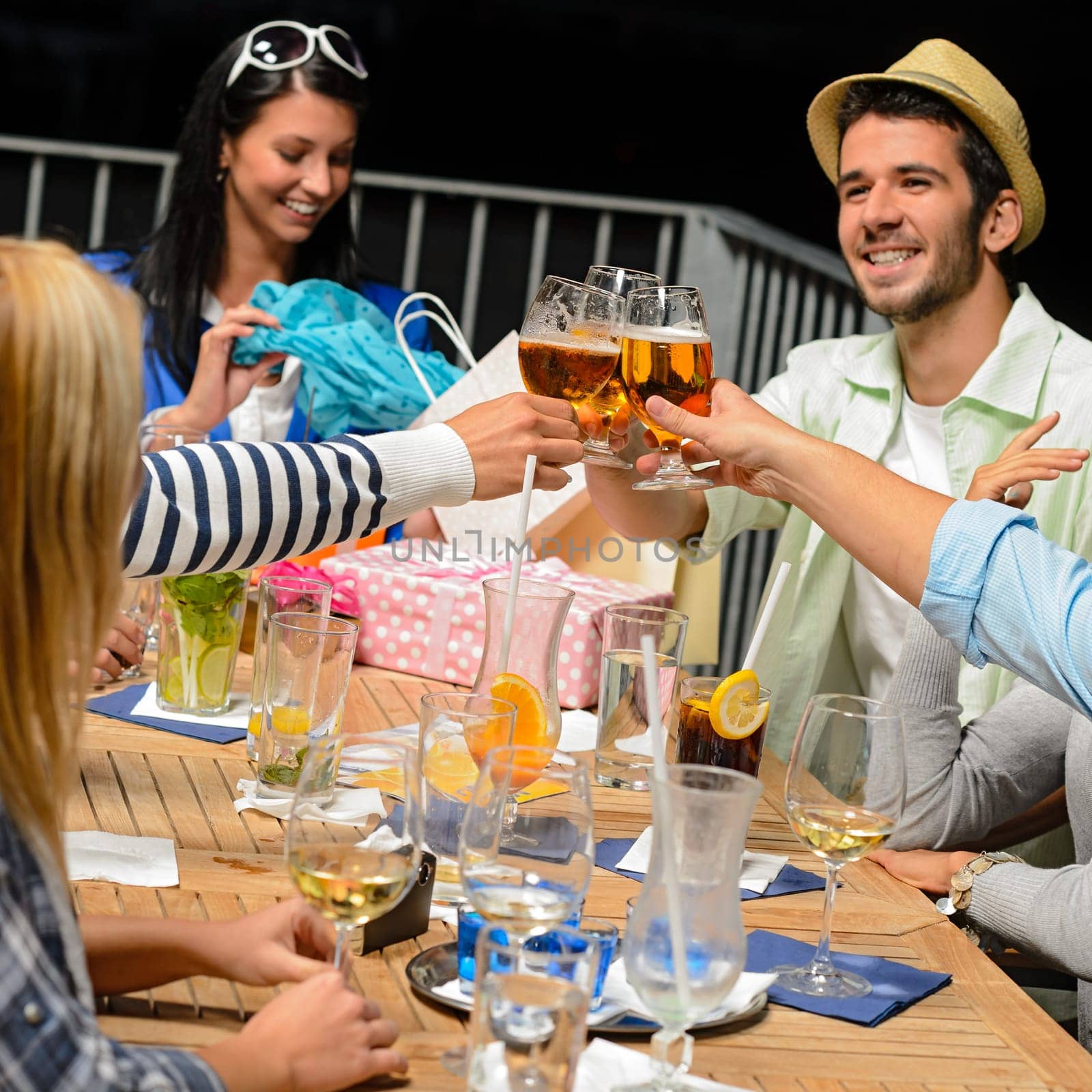 Young people celebrating birthday toasting with beer outdoors