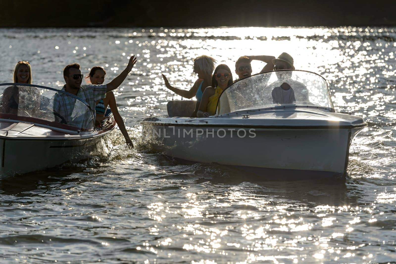 Silhouette of young people enjoying summer motorboat on lake