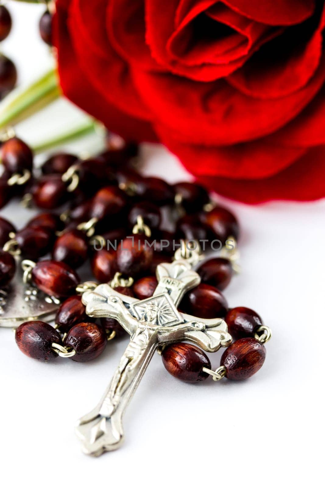 Rosary and rose on a white background
